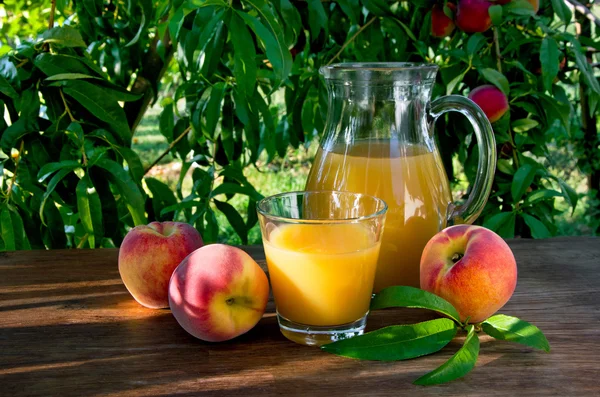 Jus de pêche dans une carafe et un verre — Photo