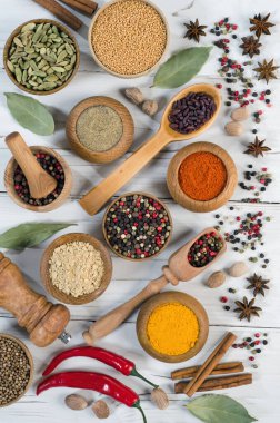 Beyaz ahşap arka planda renkli ve aromatik otlar ve baharatlar. Üst Manzara. Düz yatıyordu.