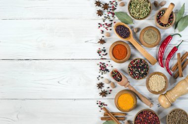 Beyaz ahşap arka planda çeşitli baharat ve bitkiler. Metnin için fotokopi alanı ile üstte. Düz yatıyordu.