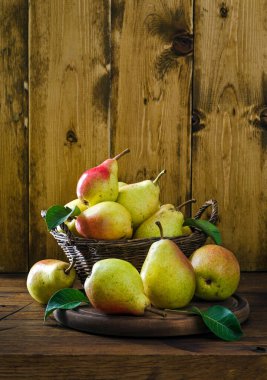 Tahta masadaki sepetin içinde taze armutlar ve metin için fotokopi alanı. Kırsal biçim.