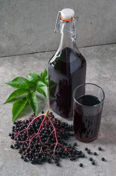 Elderberry Szirup Üvegben Üvegben Érett Bogyók Zöld Levelekkel Szürke Alapon — Stock Fotó