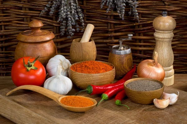 Stilleben med peppar och vitlök med trä köksredskap — Stockfoto