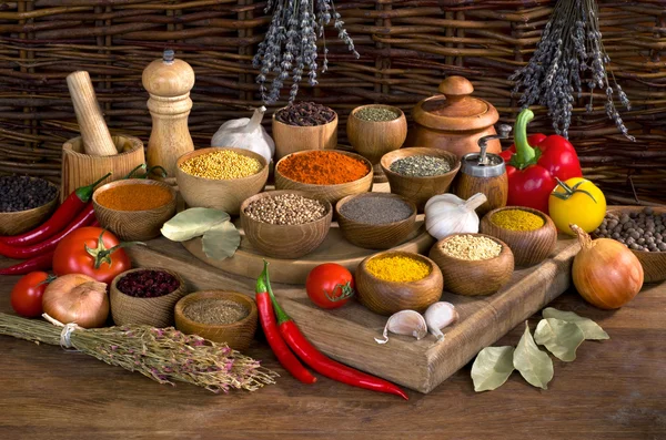 Pices and herbs in wooden bowl on wooden table — Stock Photo, Image