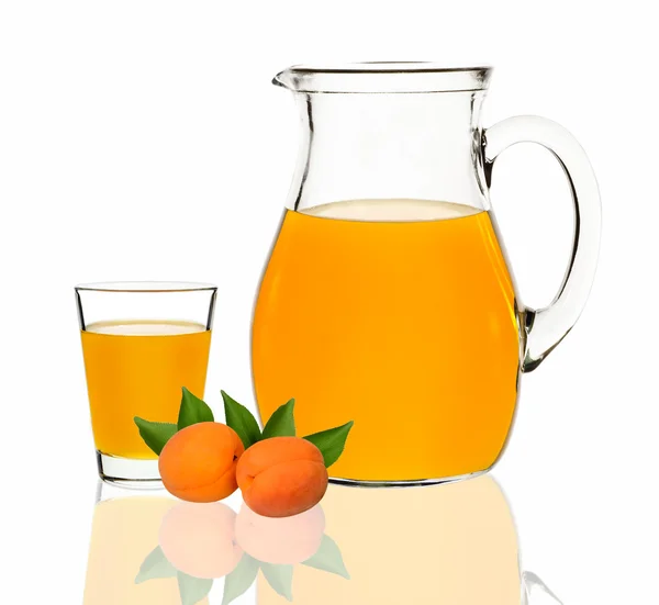 Apricot juice in a glass and carafe on a white background — Stock Photo, Image