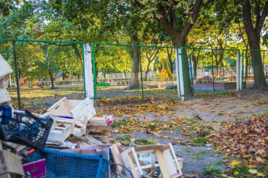 Külkedisi yakınındaki çöpler. Anaokulu çitlerinin yanındaki tahta kutular ve çöpler.