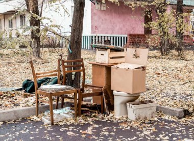 Büyük bir şehirde eski sandalyeler, kutular, tuvalet ve çöp tenekelerinin yanındaki diğer çöpler. Kyiv. Ukrayna