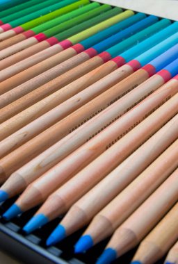 Kutudaki renkli kalemler seti. Sanatçı kalemleri seti. Tahta renkli kalemler. Sanatçının çizim aracı. Çok renkli kalemler var. Kalem noktası.