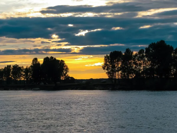 Nehirde güzel bir gün batımı ve bulutlu bir gökyüzü