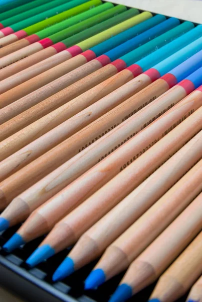 Kutudaki renkli kalemler seti. Sanatçı kalemleri seti. Tahta renkli kalemler. Sanatçının çizim aracı. Çok renkli kalemler var. Kalem noktası.