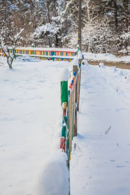 Tahtadan yapılmış çok renkli çitlerle kaplı. Şiddetli buz var, oyun alanı kapalı. Kar yağıyor
