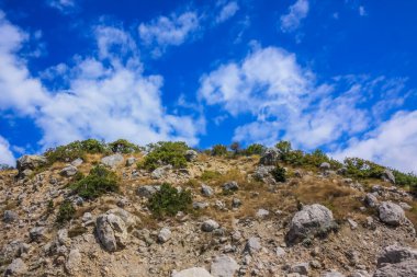 Dağlara tırmanıyor ve bulutlarla mavi gökyüzüne tırmanıyor.