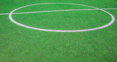 Futbol sahasının ortasında, okulun yanında suni yeşil çimenler ve beyaz çizgiler var. Amatör futbol sahası. Güneşli yaz günü