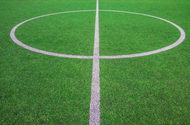 Futbol sahasının ortasında, okulun yanında suni yeşil çimenler ve beyaz çizgiler var. Amatör futbol sahası. Güneşli yaz günü