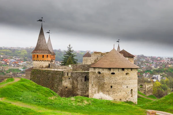 Old Kamianets-Podilskyi Castle under a cloudy grey sky. The fortress located among the picturesque nature in the historic city of Kamianets-Podilskyi, Ukraine