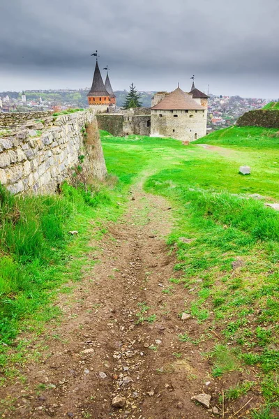 Old Kamianets-Podilskyi Castle under a cloudy grey sky. The fortress located among the picturesque nature in the historic city of Kamianets-Podilskyi, Ukraine