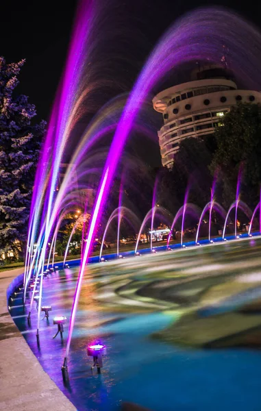 Colorful water fountains. Beautiful laser and fountain show. Large multi colored decorative dancing water jet led light fountain show at night.