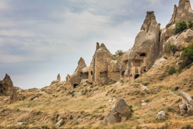 Türkiye 'nin başkenti Kapadokya' da Aşk Vadisi veya Peri Bacaları olarak bilinen inanılmaz volkanik kaya oluşumları. Mantar Vadisi, Goreme Milli Parkı, Türkiye 'deki en ilgi çekici yerlerden biri. İçinde odalar olan dağlar.