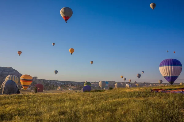 Hot air balloons flying over the valley at Cappadocia, Turkey. Goreme Balloon Festival. Beautiful hot air balloons take off at sunrise. Hot air balloons in the blue sky