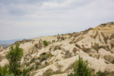 Türkiye 'nin başkenti Kapadokya' da Aşk Vadisi veya Peri Bacaları olarak bilinen inanılmaz volkanik kaya oluşumları. Mantar Vadisi, Goreme Milli Parkı, Türkiye 'deki en ilgi çekici yerlerden biri. İçinde odalar olan dağlar.