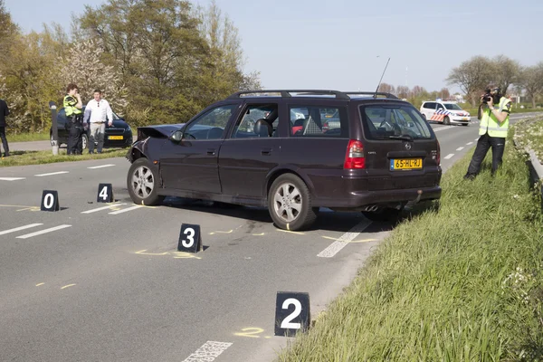 Politieagent neemt foto's, foto's van een beschadigde Duits Opel-auto — Stockfoto