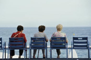 Deniz kenarı Nice ünlü mavi banklar üzerinde yaşlı kadın