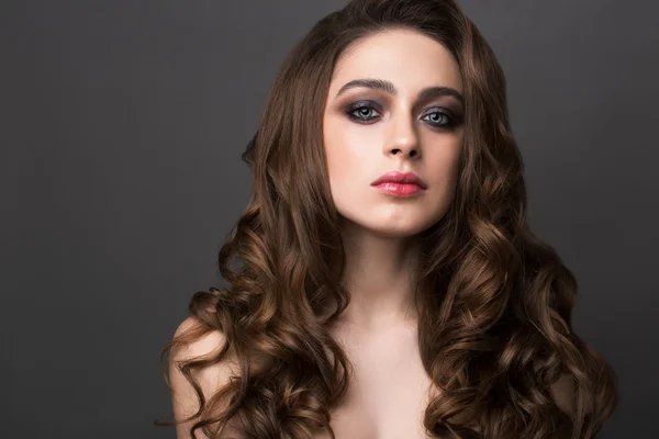 Fashion portrait of young woman with magnificent curly hair. Bru — Stock Photo, Image