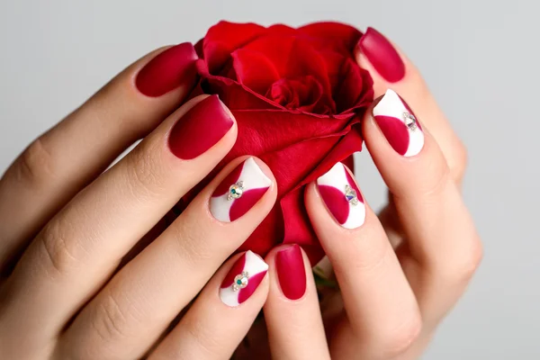Unghie di bella donna con interessante manicure rossa — Foto Stock