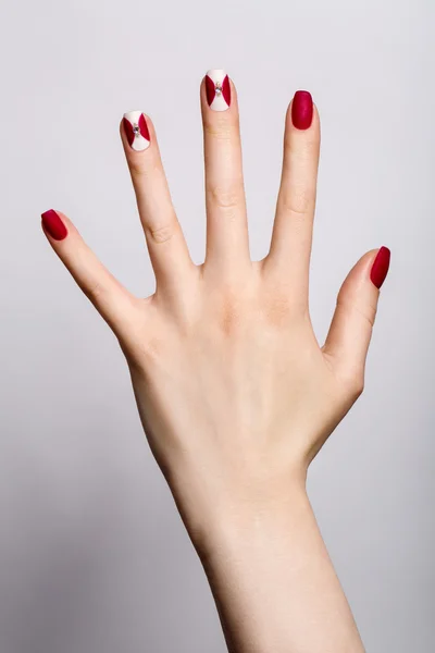 Las uñas hermosas de mujer con la manicura interesante roja — Foto de Stock