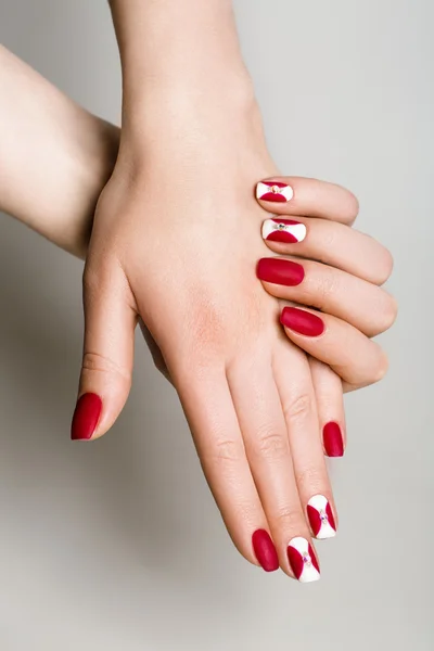 Unghie di bella donna con interessante manicure rossa — Foto Stock