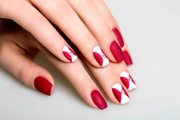 Unghie di bella donna con interessante manicure rossa — Foto Stock