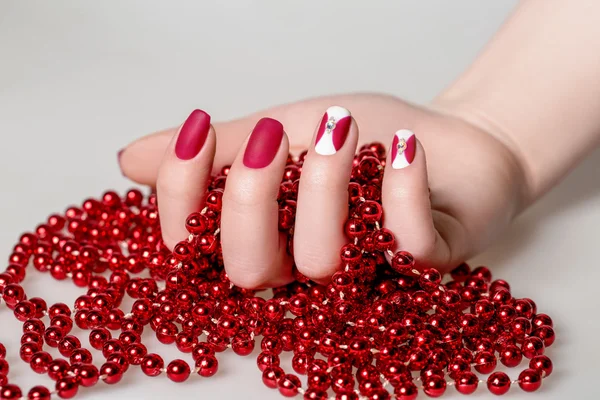 Las uñas hermosas de mujer con la manicura interesante roja — Foto de Stock