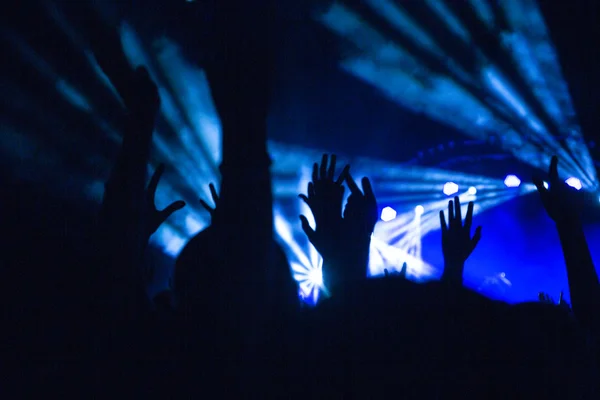 Silhuetas de multidão de concerto na frente de luzes de palco brilhantes — Fotografia de Stock