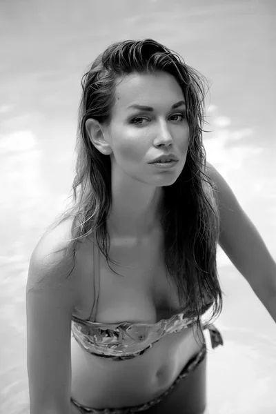 Hermosa mujer tomando el sol en una piscina — Foto de Stock