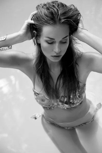 Красивая женщина загорает в бассейне — стоковое фото