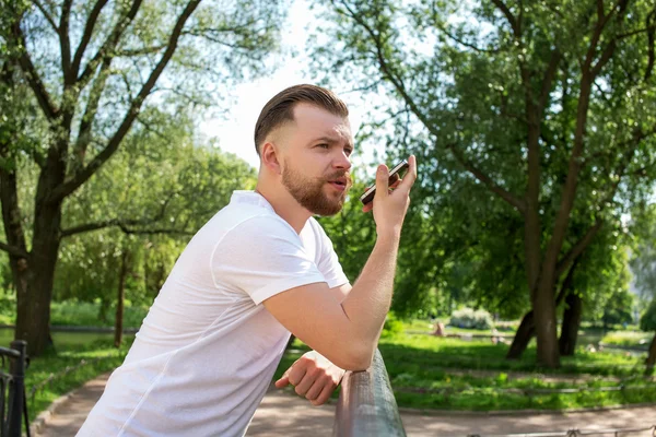 Hpster Mann telefoniert mit Smartphone im Park mit ernstem und c — Stockfoto