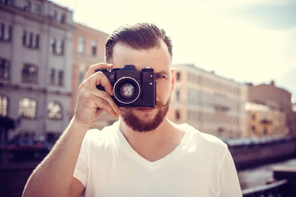 Homem Hipster com uma câmara na cidade. Viajar. Foto vintage . — Fotografia de Stock