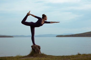 genç kadın dağ gölü yoga uygulamak