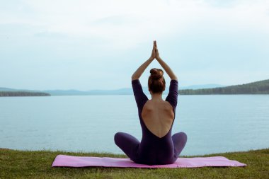 genç kadın dağ gölü yoga uygulamak