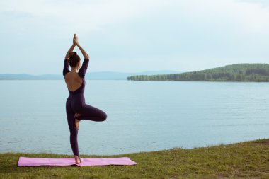 genç kadın dağ gölü yoga uygulamak