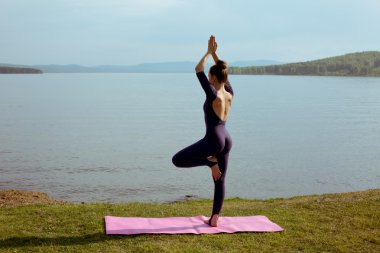 genç kadın dağ gölü yoga uygulamak