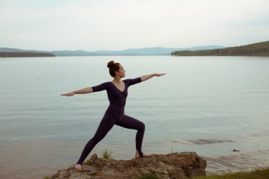 genç kadın dağ gölü yoga uygulamak