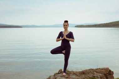 genç kadın dağ gölü yoga uygulamak