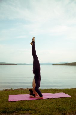 genç kadın dağ gölü yoga uygulamak
