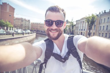 Genç adam bir sakal ve bıyık güneş gözlüğü ve beyaz t-