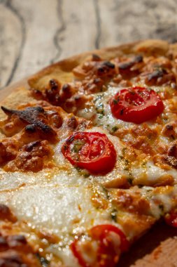 Kırsal ahşap masada sıcak ev yapımı Pepperoni Pizza. Domatesli pizza, peynirli ve fesleğenli..