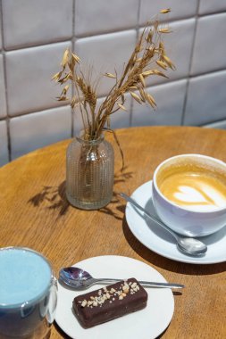 Lokanta masasında tatlı ile bir fincan kahve ve kibrit.