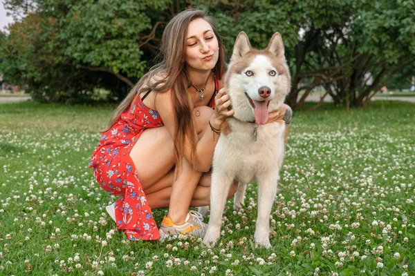 Gadis Cantik Dengan Rambut Panjang Dalam Gaun Merah Memeluk Anjing — Stok Foto