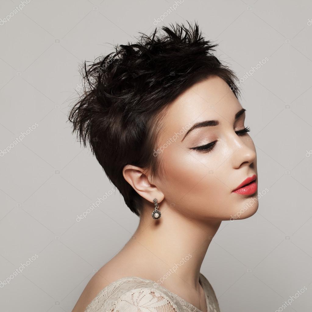 Retrato de uma menina bonita com cabelo curto no cabelo e maquiagem  brilhante