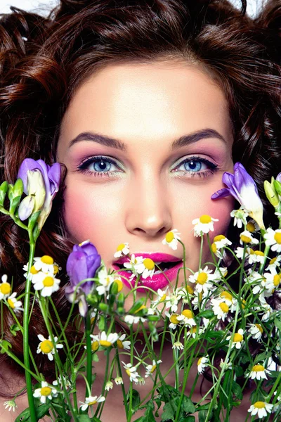 Portrait of beautiful young woman with flowers. Perfect makeup.