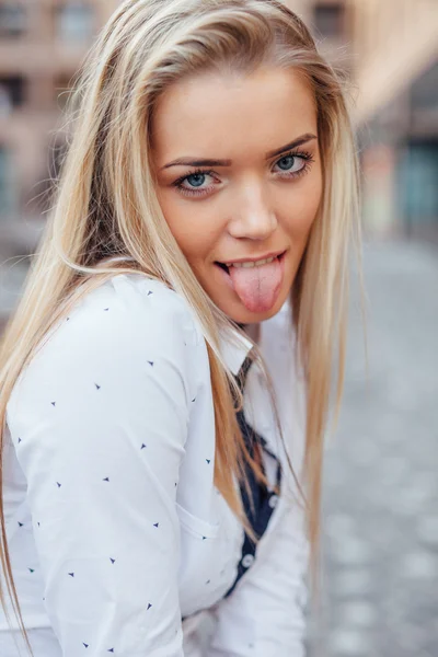 Egy boldog fiatal lány portréja. Ő mutatja a száját — Stock Fotó